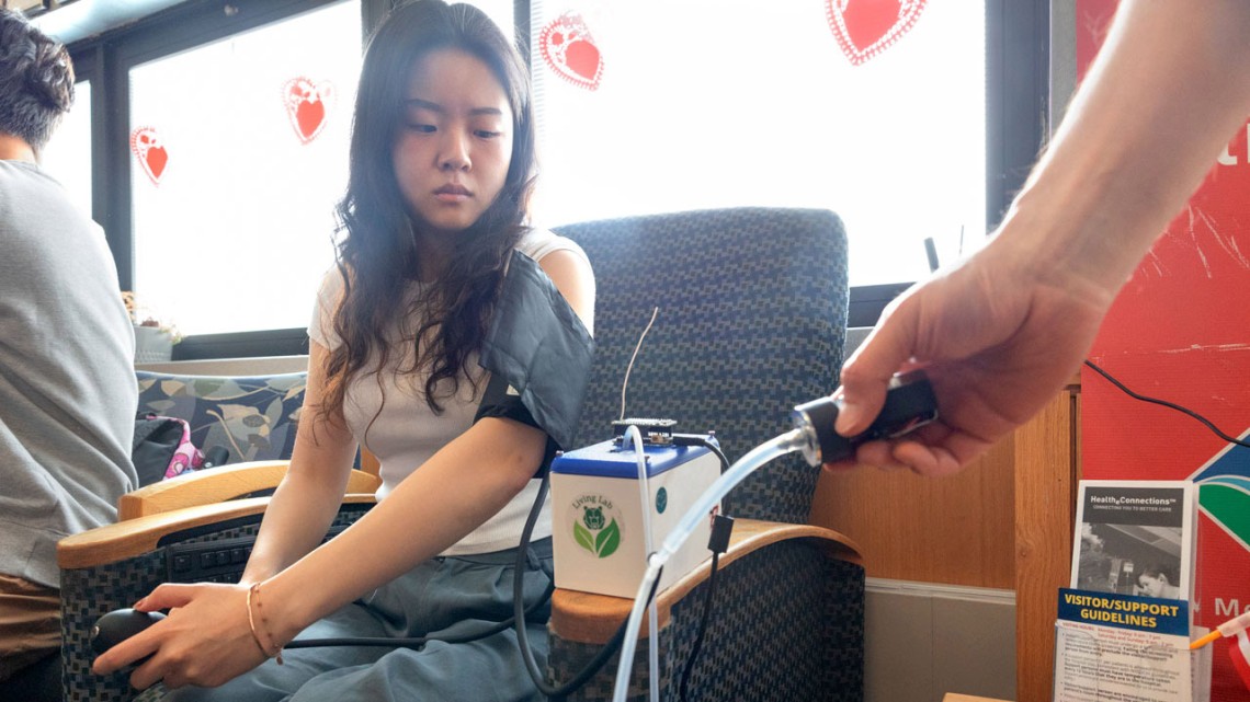 Adrienne Yoon ’25 demonstrates the use of the manual blood pressure cuff and all-in-one device at Cayuga Medical Center.