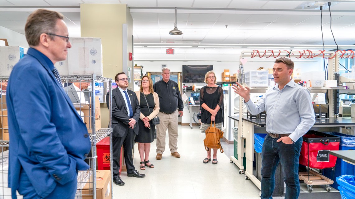 Dr. Diego Diel, right, director of the Virology Laboratory, led a tour for attendees before the event.