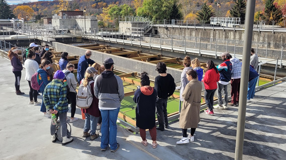 People standing around a portion of a wastewater treatment plant