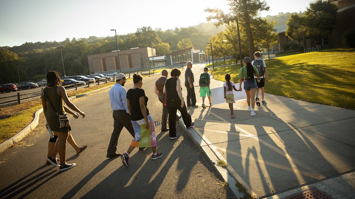 Member of the ICSD community walk across the Ithaca High School campus.