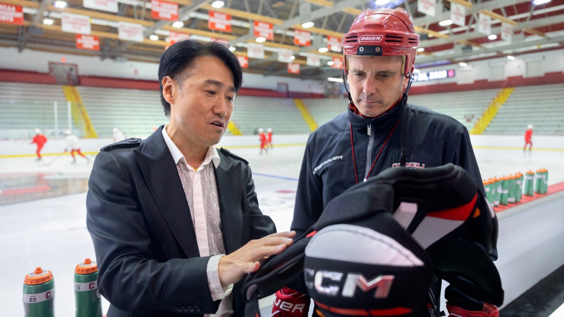 Heeju Park, associate professor of apparel design, speaks with Doug Derraugh ’91, the Everett Family Head Coach of Women’s Ice Hockey, about hockey protective equipment ahead of practice at Lynah Rink.
