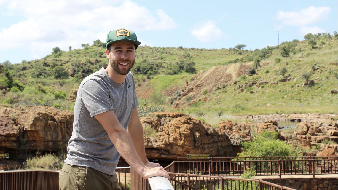 Postdoctoral fellow Paul Friesen smiles for a photo in scenic South Africa.