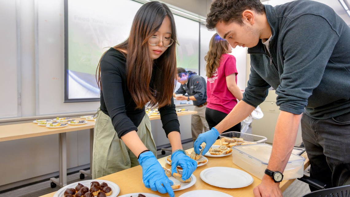 Tracy Zeng and Jonathan Gotian assemble  pizza bites for the in-class tasting