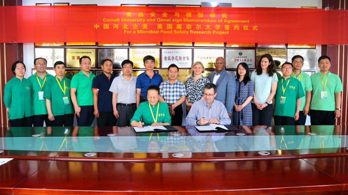Yuqi Zhao, president of Qimei, left, and Martin Wiedmann, sign an agreement