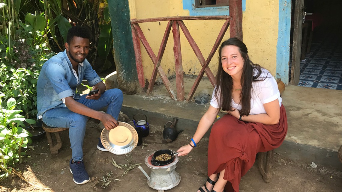 Two people cook food outside of a home
