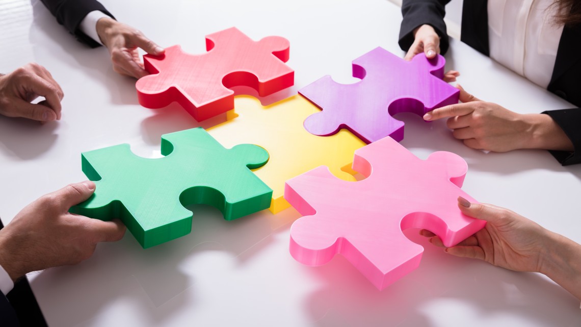 Employees connect colorful puzzle pieces