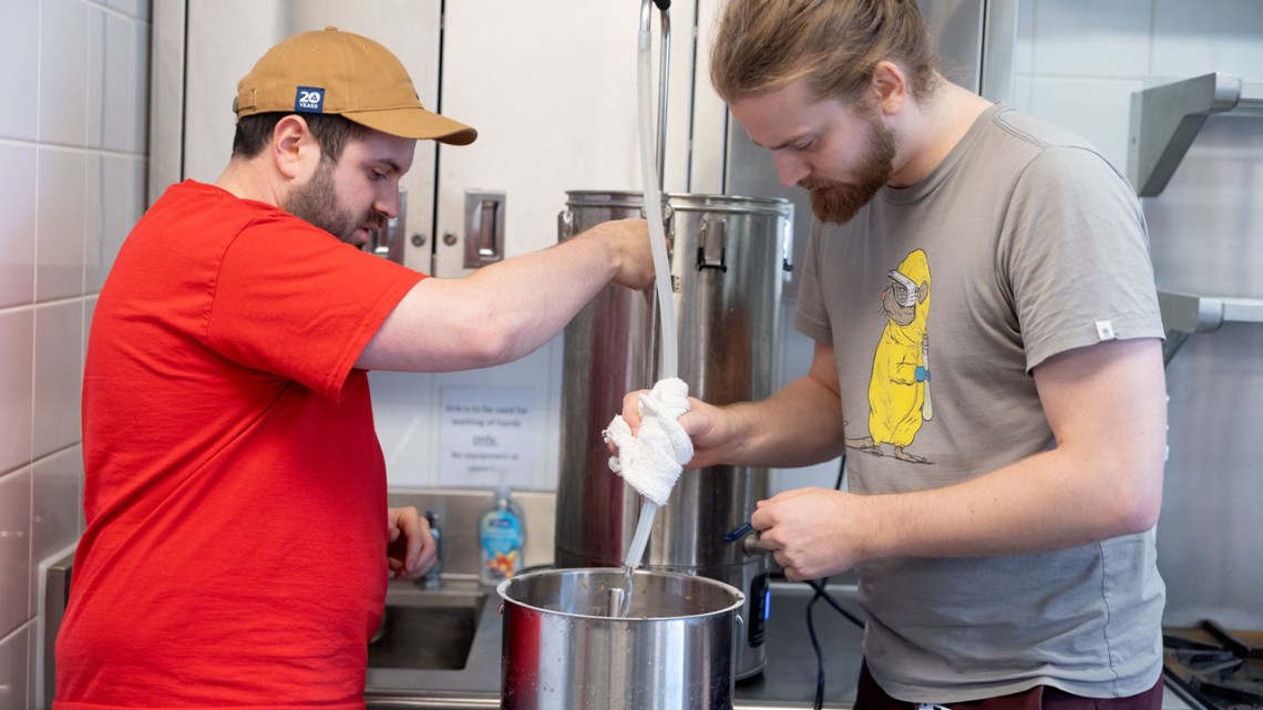 Dean Hauser, left, and Andy Kalenak "sparge" the grain bed, running very hot water through to fully extract the sugars from the grains.