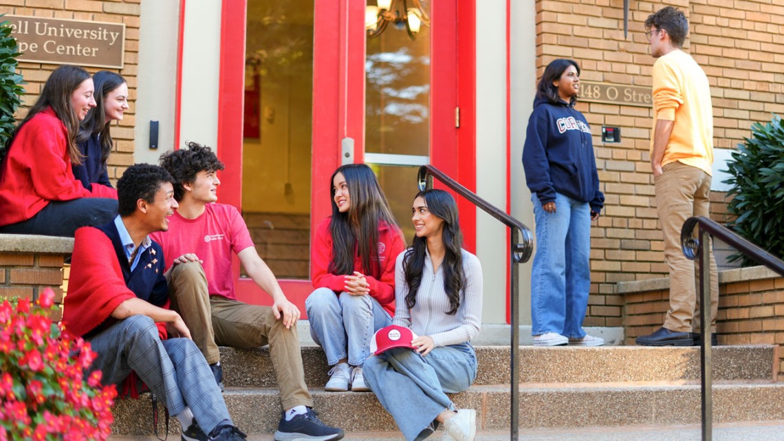 Cornell undergraduates enjoy the fall sunshine on the steps of the Wolpe Center.