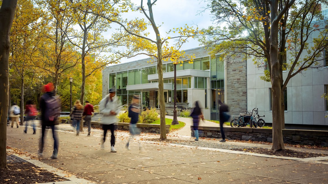 Students walk past Cornell Health building on Ho Plaza