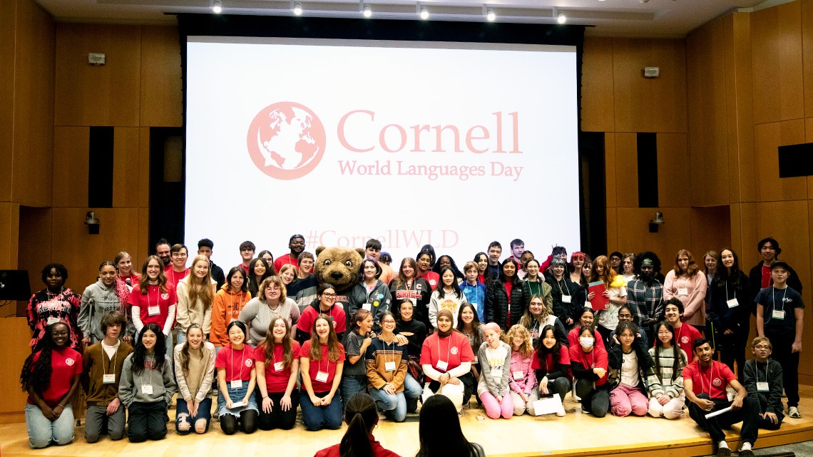 Group of students, faculty and staff posing on a stage