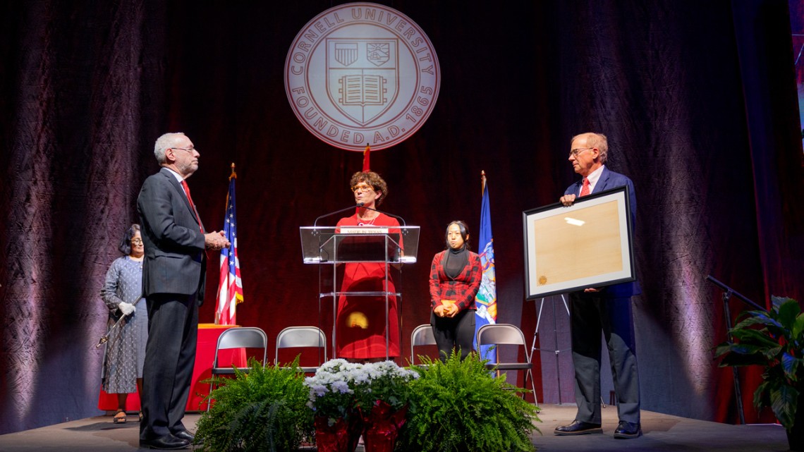 Michael I. Kotlikoff is presented with the official University Charter by Ezra Cornell, right, and Anne Meinig Smalling, center, as he is officially sworn in as the 15th president of Cornell University.