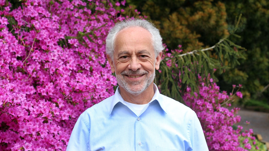 Man standing in front of blooming shrub