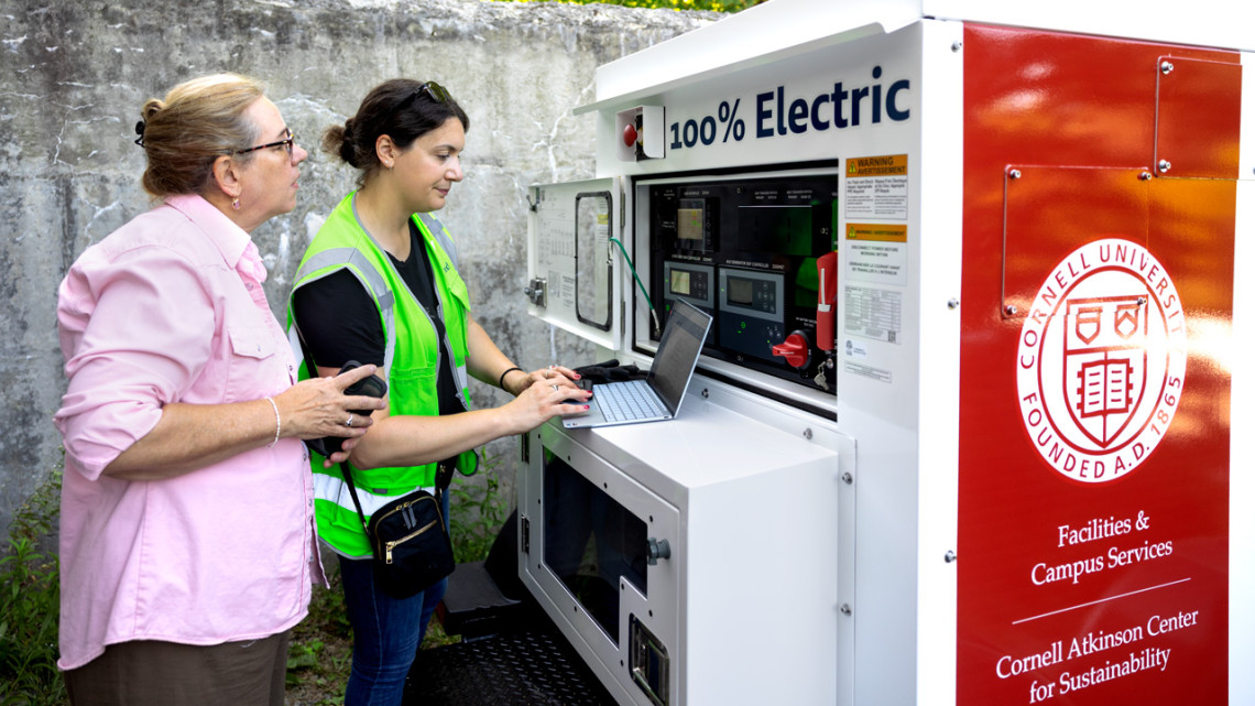 Eva Gardow (left), program manager for the Electric Power Research Institute, works with Tess M. Williams ’15 (right), project manager for energy storage company Viridi, to test the charging infrastructure for a mobile battery energy storage system that will now be used to power Cornell's signature outdoor events.