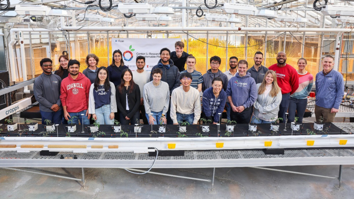 The team posing with equipment and plants