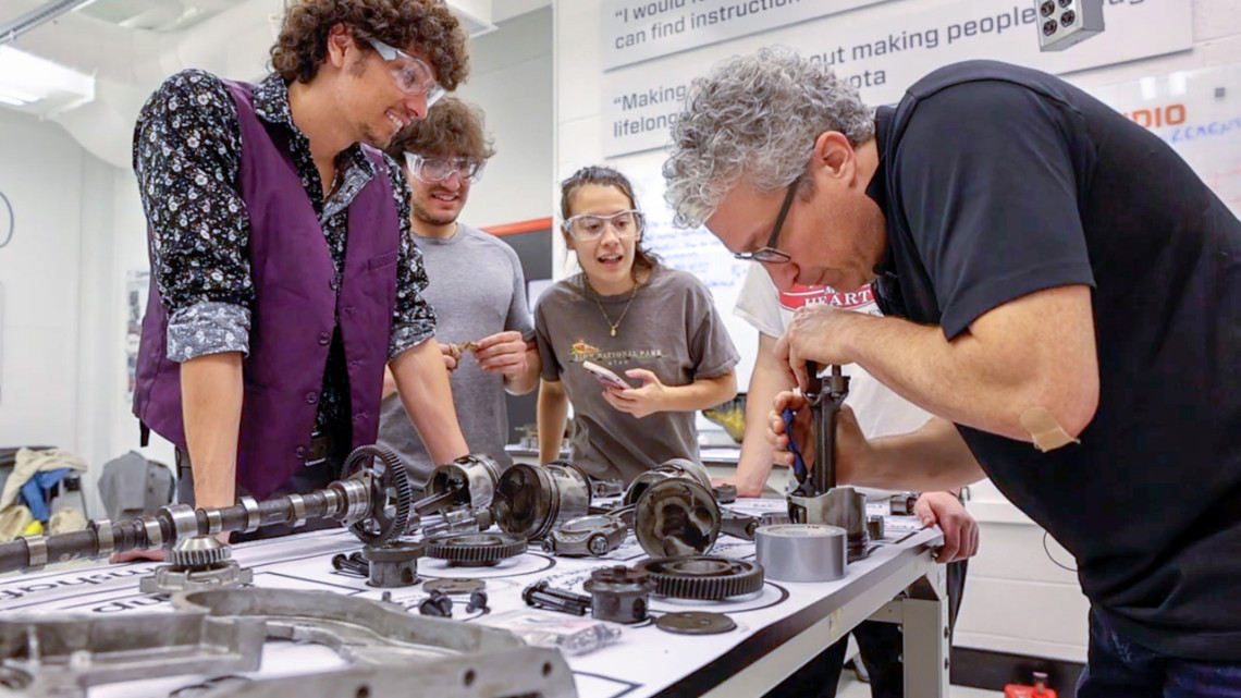 Students learn about mechanical engineering by disassembling an engine in the Learning Studios, spearheaded by Brian Kirby, the Meinig Family Professor of Engineering (right).