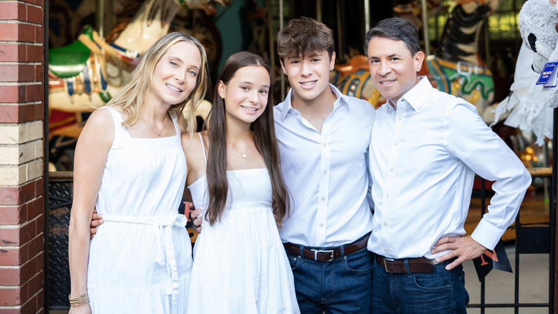 Uribe family standing in front of a carousel