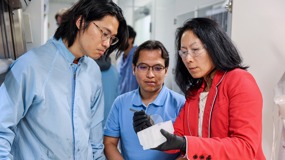 From left: doctoral student Chuan Chang; research associate Jimy Encomendero; and Huili Grace Xing, the William L. Quackenbush Professor of Engineering, examine a material sample in the Jena-Xing Lab.
