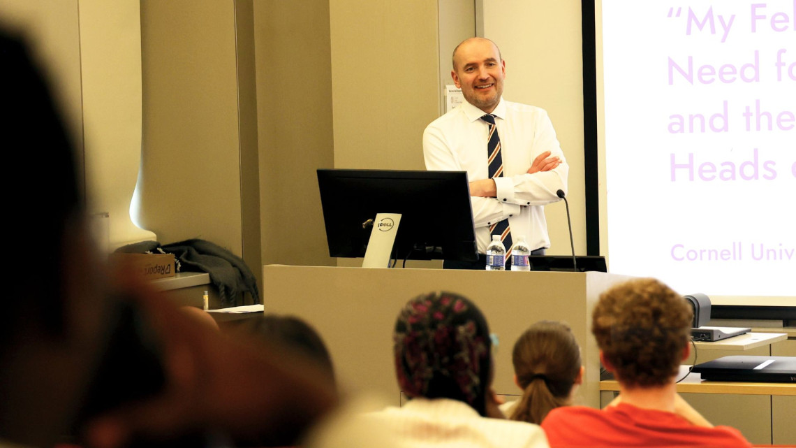 Guðni Thorlacius Jóhannesson stands at a podium in front of students