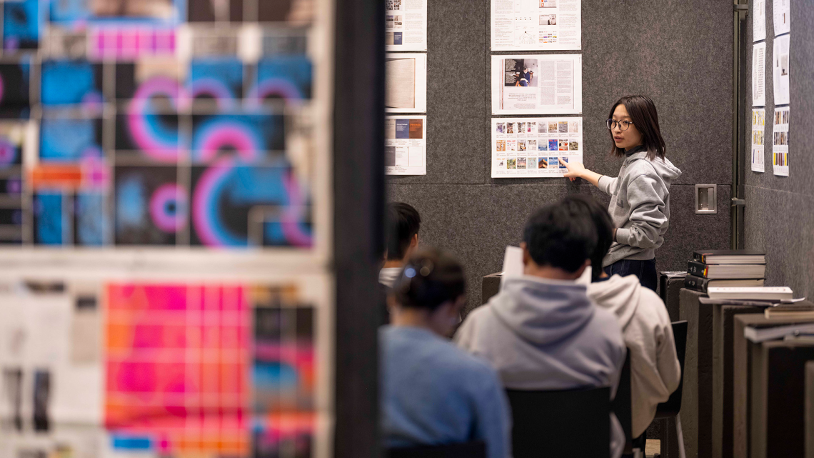 Student presenting pinned up work.