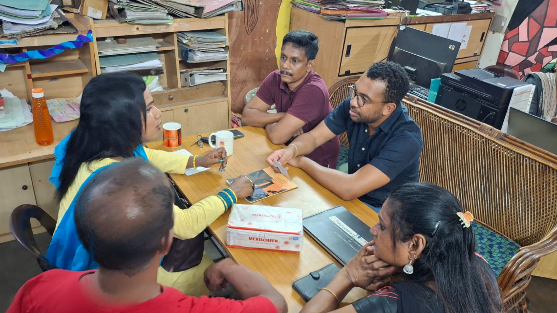 People sitting around office table in conversation 