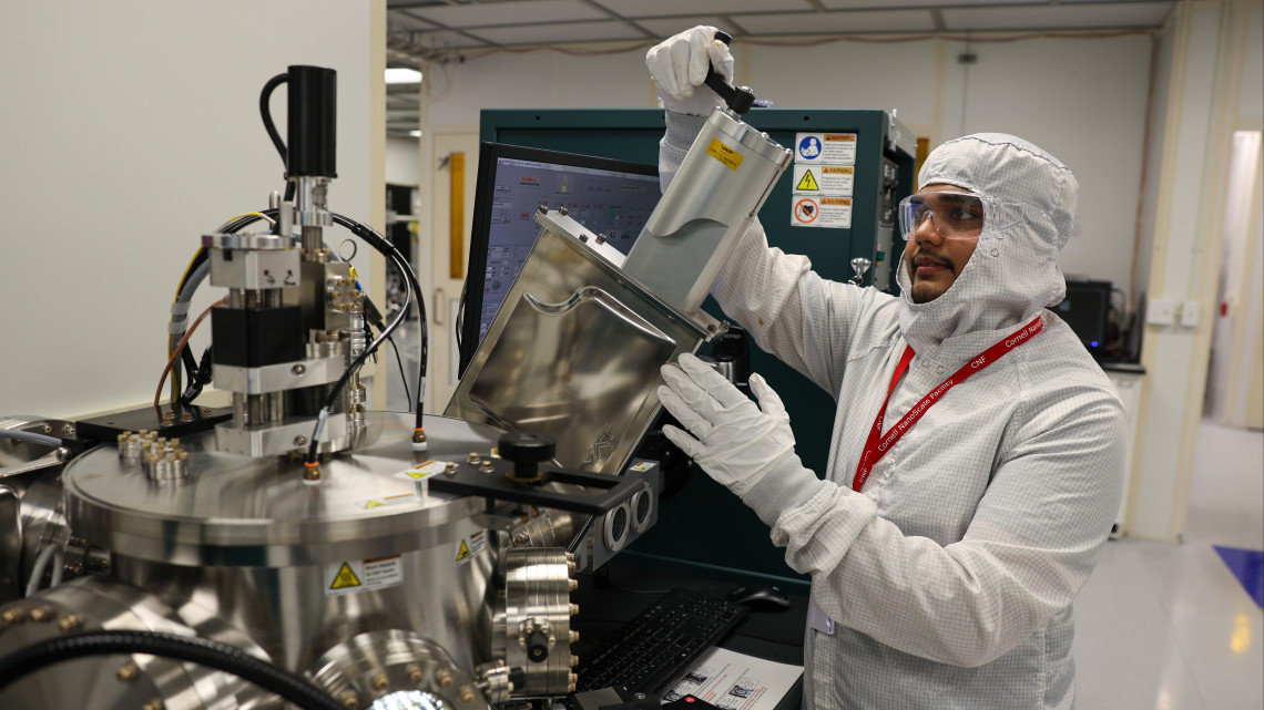 student in clean room works with research equipment