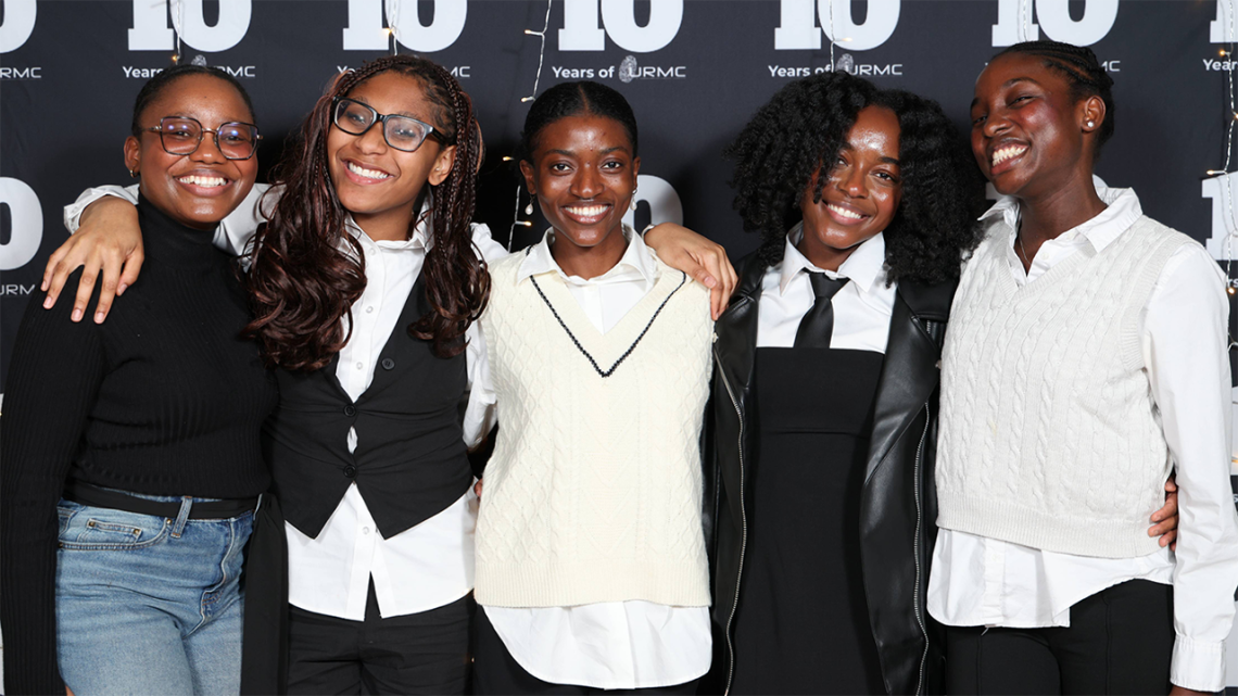 Five students of color pose for a photo