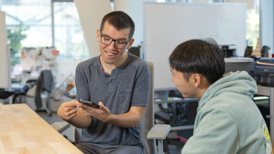 Doctoral student Tobias Weinberg communicates with another student using alternative AAC software on a smartphone
