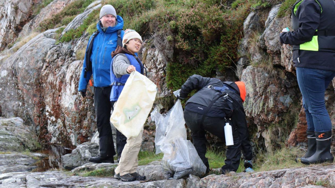 Fulbrighter Audrey Su works with a team picking up trash in a natural area in Norway.