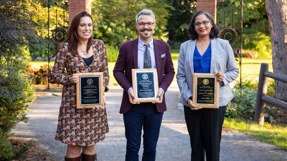 Three of the four 2019 Postdoc Achievement Award recipients stand outside the Big Red Barn