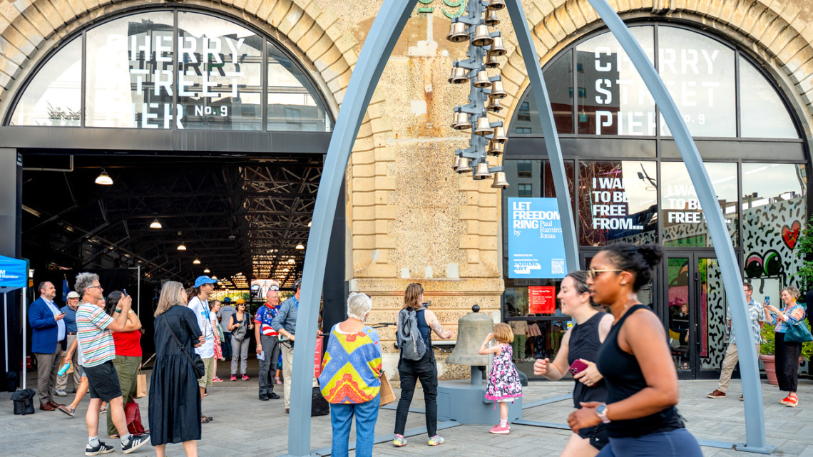 Creator Paul Ramírez Jonas, at left in a striped shirt, takes a photo of his art installation