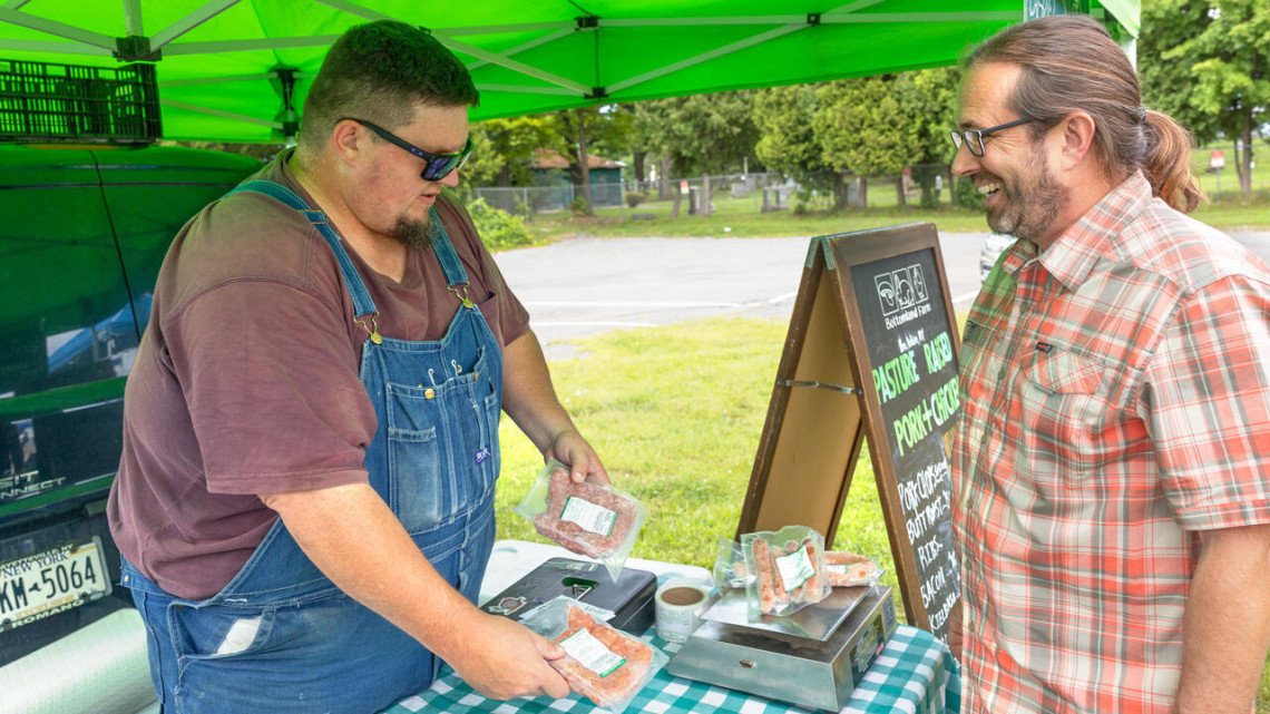Matthew LeRoux (right), Cornell extension associate and founder of MeatSuite, talks with MeatSuite-user Bill Morse of Bottomland Farm at the East Hill Plaza Farmers’ Market on Aug. 19.