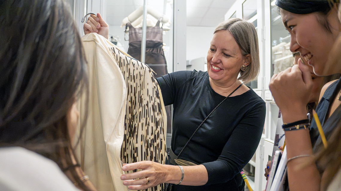 Catherine Blumenkamp, associate director of the Cornell Fashion + Textile Collection, shows a white satin bolero with porcupine quills to students at the beginning of the semester. Alternating white and brown quills are attached by metal loops and white thread. This piece was shown as part of the Spring 2007 Haute Couture collection.