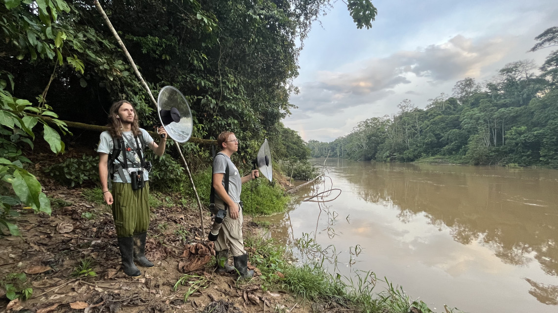 Researchers in Ecuador hold up tools to record bird sounds in Ecuador.