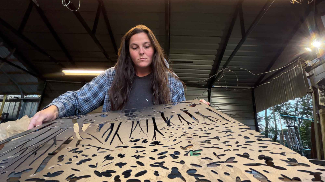 person looking at metal sculpture on table