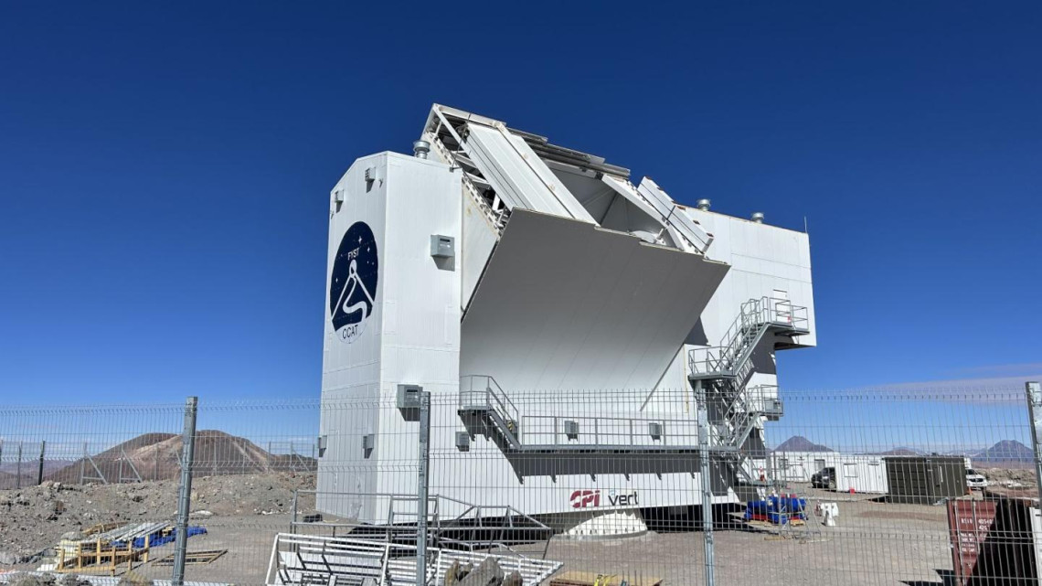 Fred Young Submillimeter Telescope, a boxy white structure on dry ground with a vivid blue sky overhead