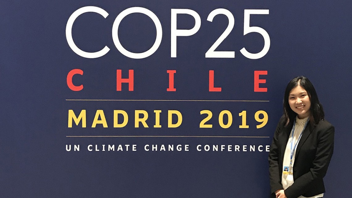 Alice Soewito stands in front of banner at 2019 UN Climate Change Conference 
