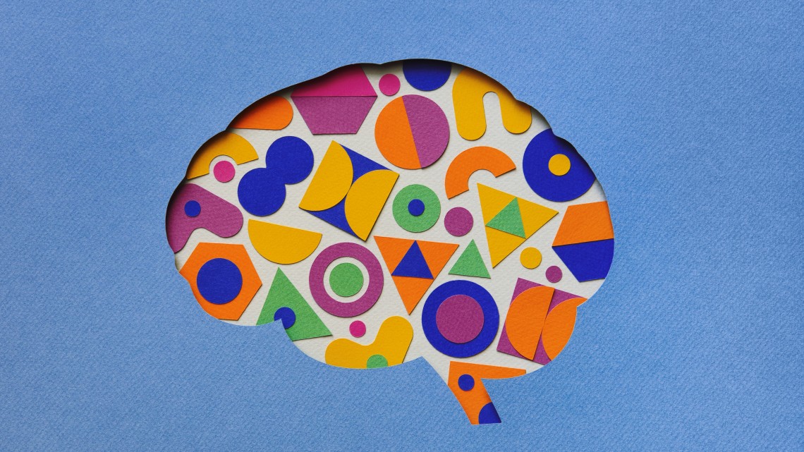 Outline of the human brain with colorful paper chips inside