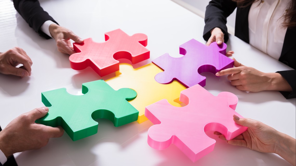 Employees connect colorful puzzle pieces