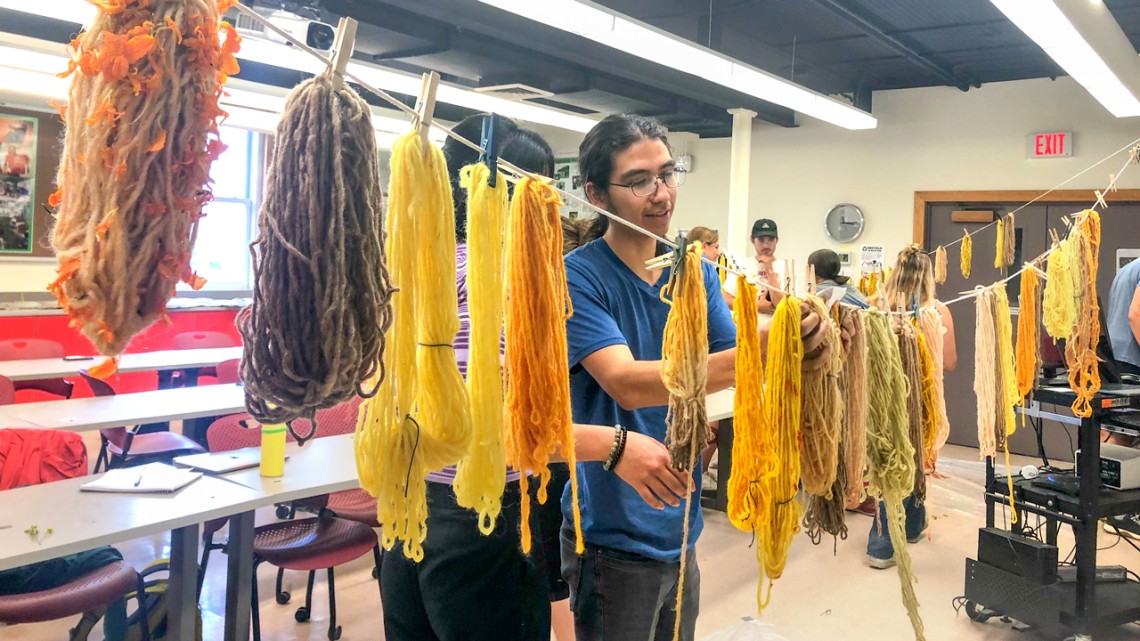 As part of the Earth Projects class, Sam Jurado '24 hangs naturally dyed yarn to dry. 