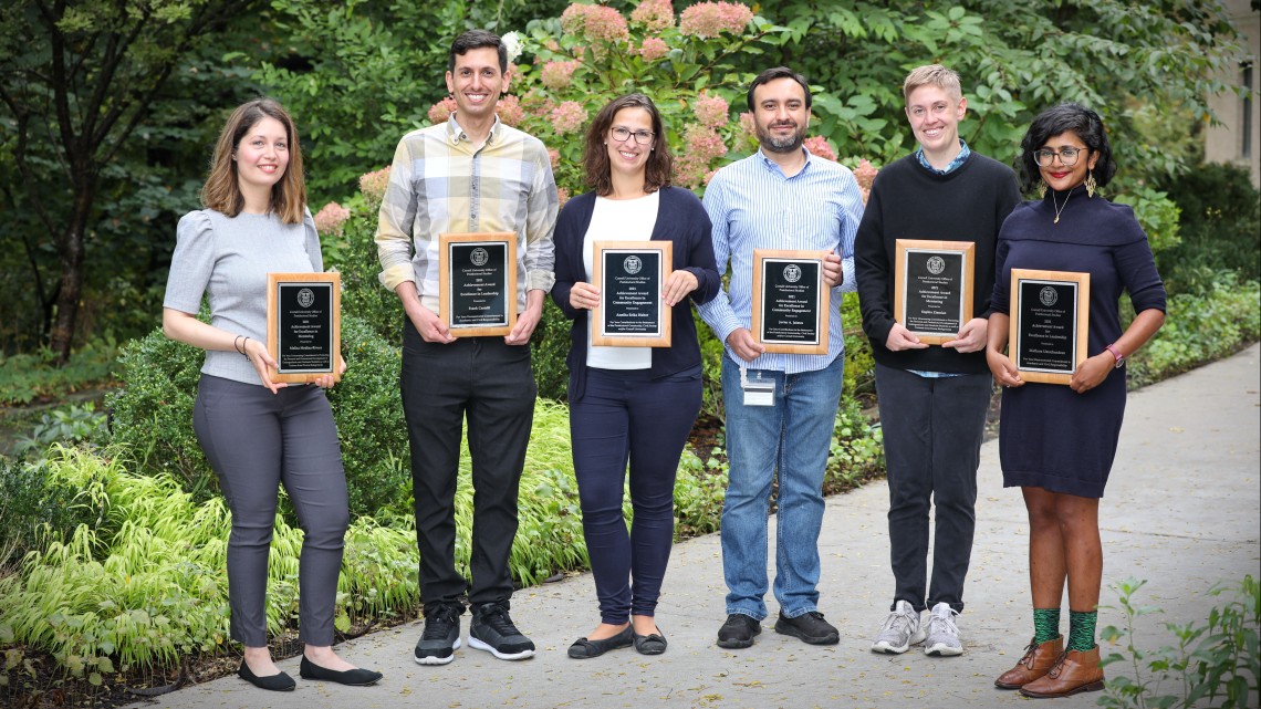 Recipients of the 2021 Postdoc Achievement Awards holding their plaques