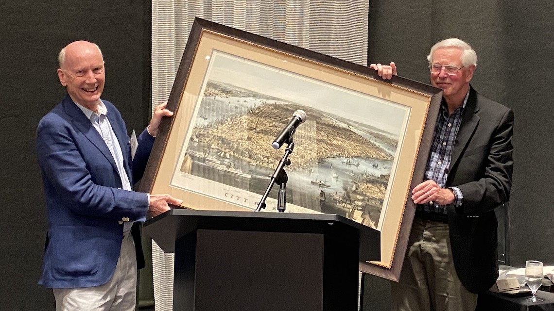 Tom O'Rourke, right, holds framed illustration of New York City with Robert Mair, left