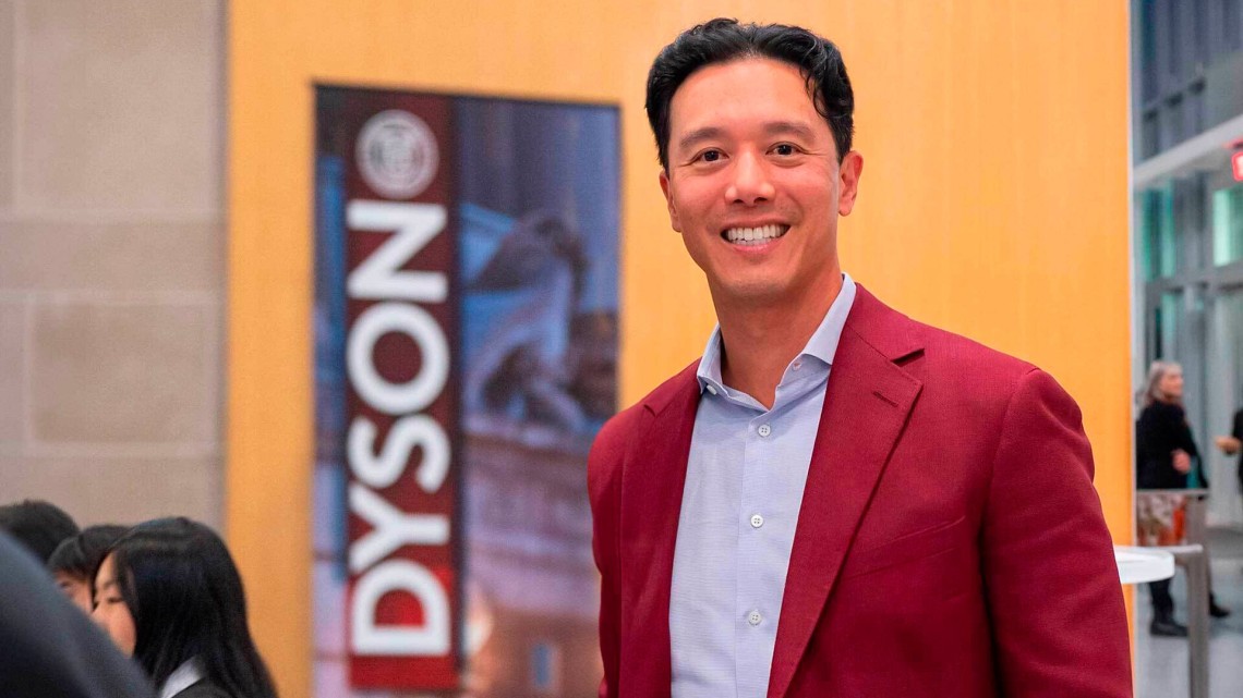 Image of John Wu next to a Dyson banner