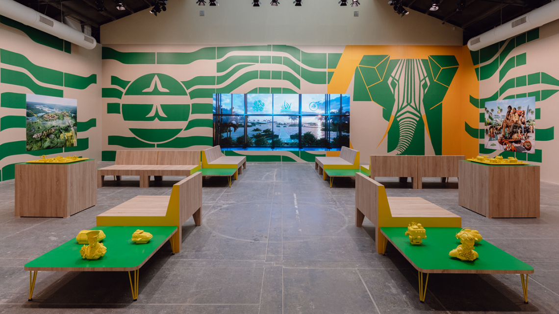 Fictional waiting lounge featuring bright green tables, yellow sculptures, and hung travel posters
