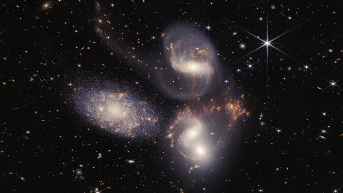 In this image of Stephan’s Quintet, a visual grouping of five galaxies from the James Webb Space Telescope, sparkling clusters of millions of young stars and starburst regions of fresh star birth are revealed. Sweeping tails of gas, dust and stars are being pulled from several of the galaxies due to gravitational interactions. 