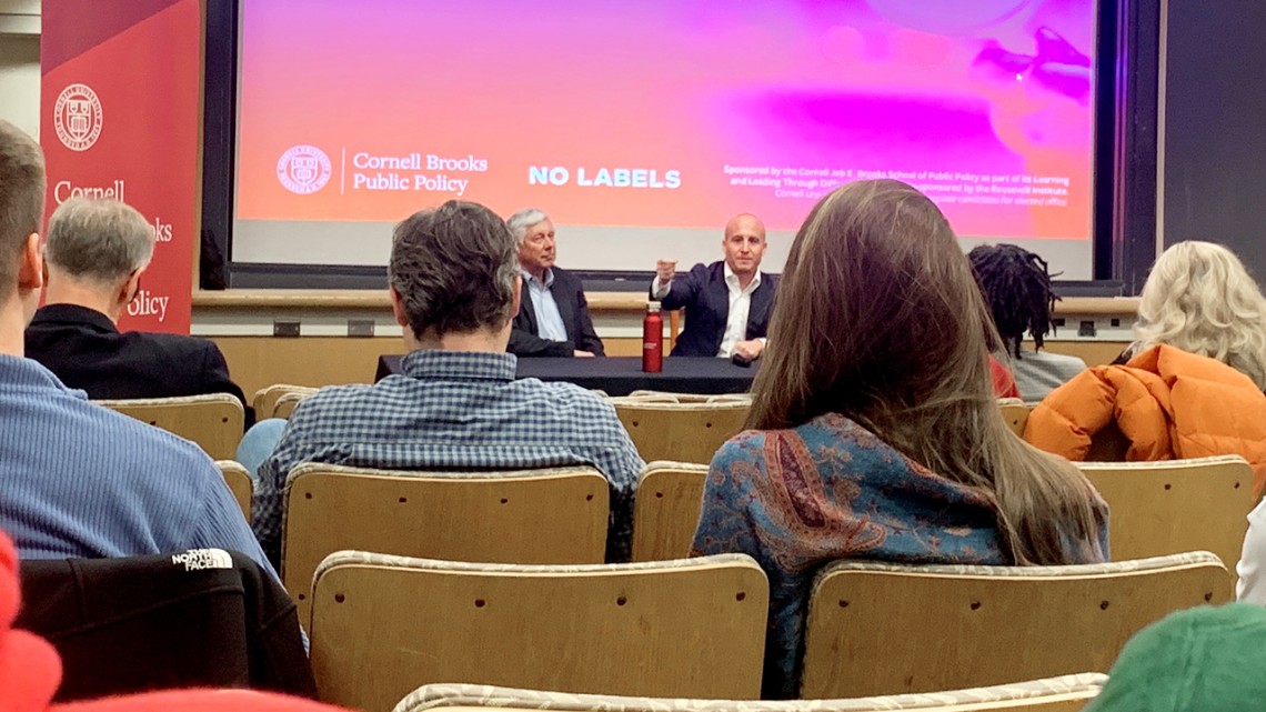 Former congressmen Fred Upton and Max Rose in a lecture hall with people watching