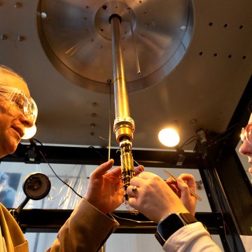 John Marohn, professor of chemistry and chemical biology, and doctoral candidate Virginia McGhee inspect a electrostatic force microscope that is used to study perovskites.