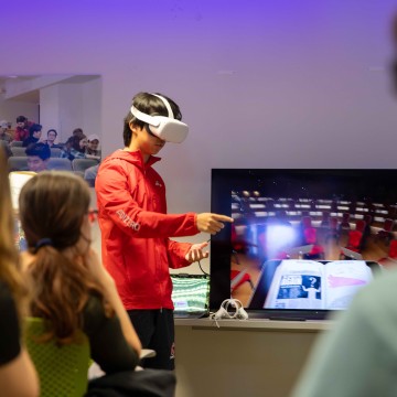 Students practice conducting music while wearing a virtual reality headset.