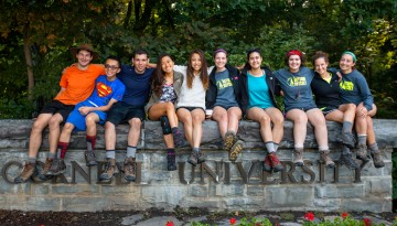 Students sitting on the Cornell University sign wall in 2015. 
