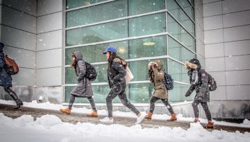 Students walk past Duffield Hall in winter.