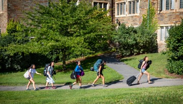 Students carrying luggage to the residence halls. 